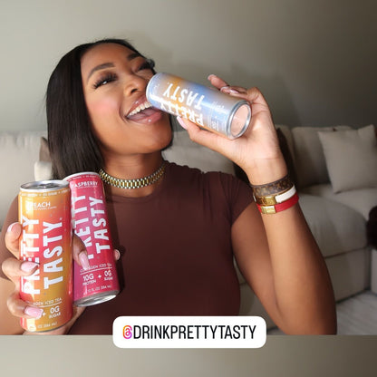 Woman holding and smiling with colorful drink cans in a casual setting