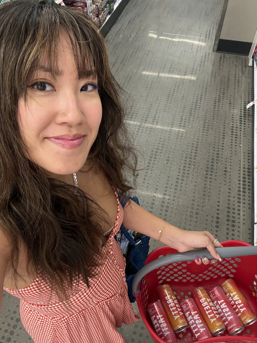 Shopper carrying a Target basket of Pretty Tasty cans